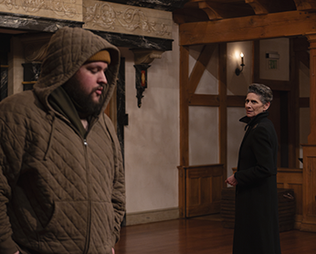 Kent in quilted, hooded jacket, zipped up to his beard stands left as Lear, turned in the opposite direction and wearing a black overcoat stands stiffly as he interrogates him. 
